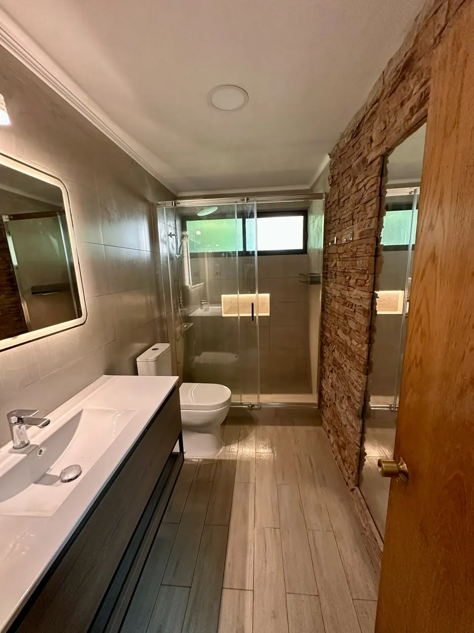 Remodelación de baño con muro de piedra en Viña del Mar